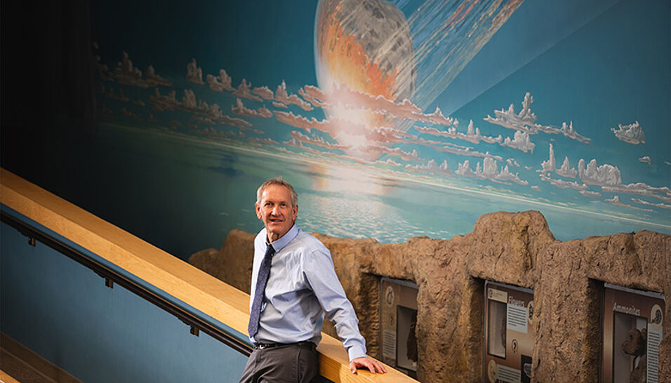 Mark Boslough in front of a impact picture.